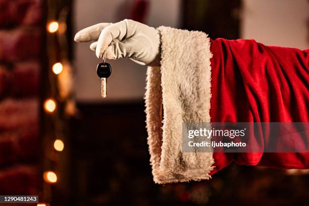 male hand in white glove and santa clause costume holding key - santa giving out presents stock pictures, royalty-free photos & images