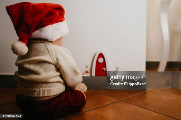 little kid sitting near a gnomes door - garden gnome stock pictures, royalty-free photos & images