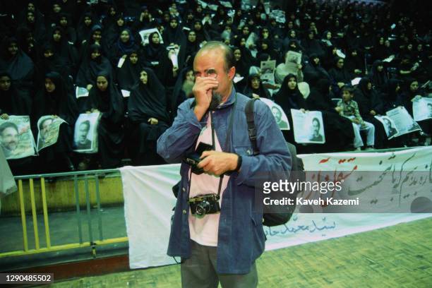 Magnum photographer of Iranian origin Abbas Attar, commonly known by his first name Abbas holds a magnifying lupe to his eye during a rally of...