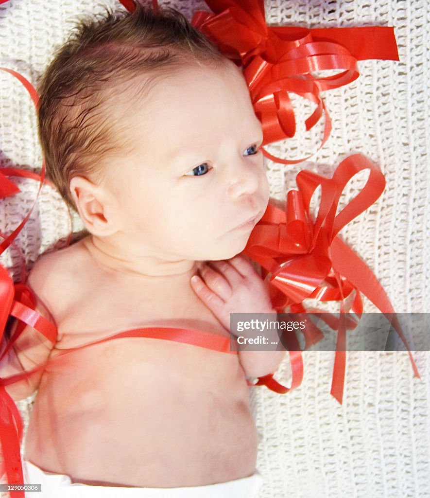 Baby boy and gift wrapping ribbon