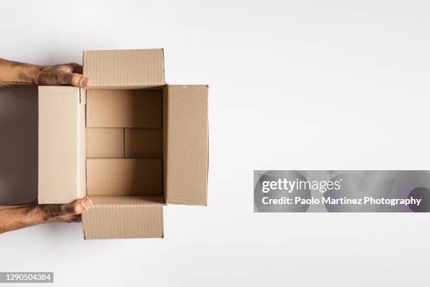 directly above shot of hands holding open cardboard box over white background - delivery person on white stock pictures, royalty-free photos & images