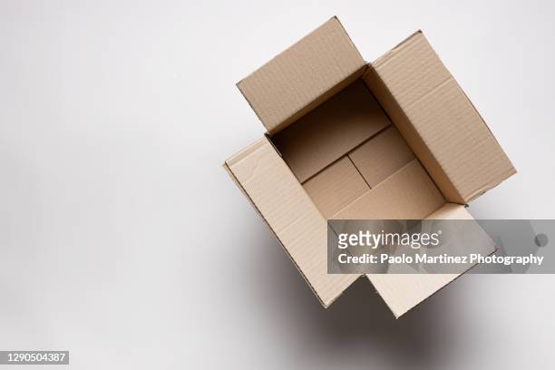 directly above shot of open cardboard box over white background - envase de cartón fotografías e imágenes de stock
