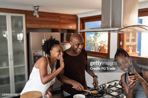 adolescente niña filmando padres cocinando o en una videollamada en casa - plano fijo fotografías e imágenes de stock