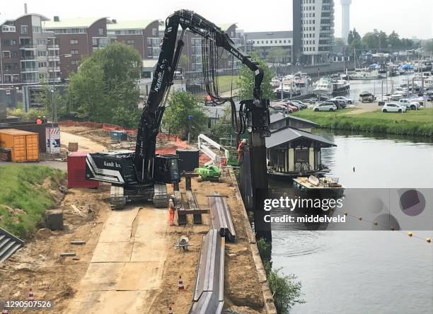 het herstellen van een keermuur - hijskraan nederland stockfoto's en -beelden