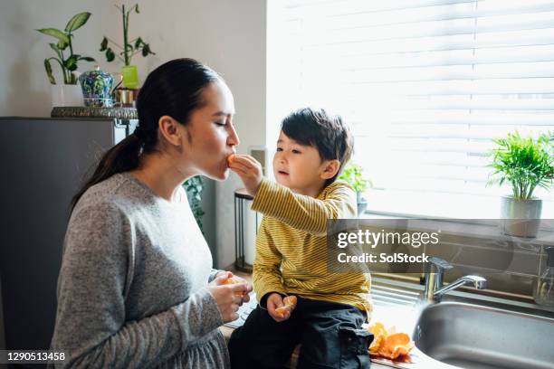 snacking en mandarinas - fond orange fotografías e imágenes de stock