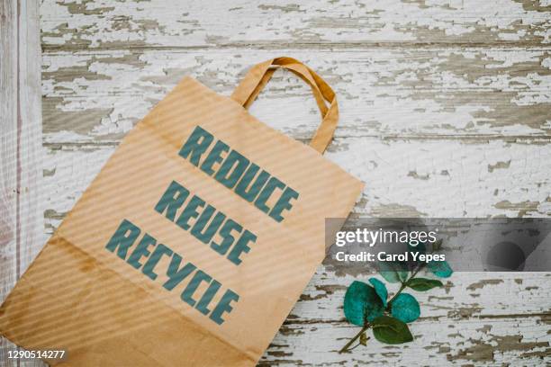 recycled paper bag  on green background. reuse, reduce and recycle writes on  it - reusable 個照片及圖片檔