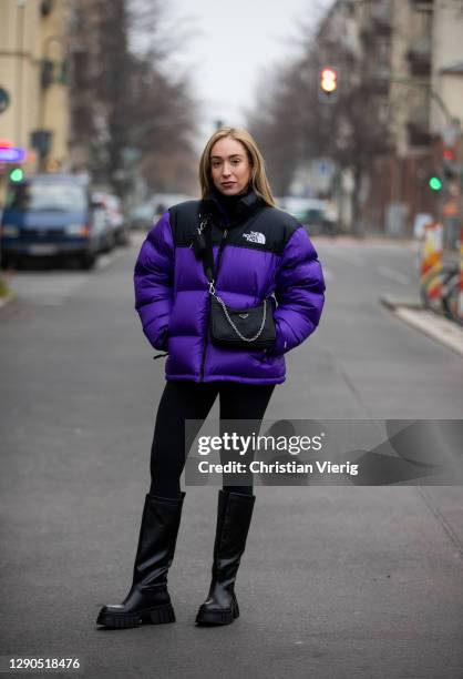 Sonia Lyson is seen wearing black boots Zara, Prada bag, two tone puffer down feather jacket The North Face in purple and black, Lululemon leggins on...