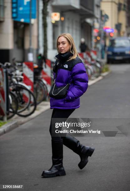 Sonia Lyson is seen wearing black boots Zara, Prada bag, two tone puffer down feather jacket The North Face in purple and black, Lululemon leggins on...