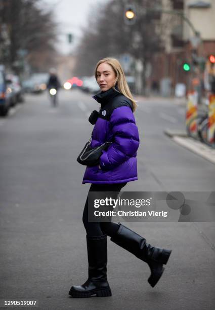 Sonia Lyson is seen wearing black boots Zara, Prada bag, two tone puffer down feather jacket The North Face in purple and black, Lululemon leggins on...