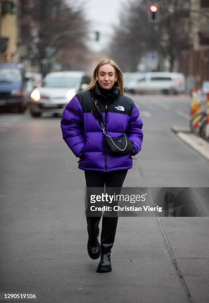 Sonia Lyson is seen wearing black boots Zara, Prada bag, two tone puffer down feather jacket The North Face in purple and black, Lululemon leggins on...