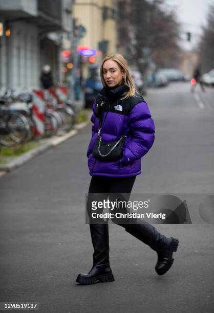 Sonia Lyson is seen wearing black boots Zara, Prada bag, two tone puffer down feather jacket The North Face in purple and black, Lululemon leggins on...