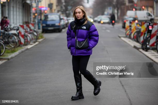 Sonia Lyson is seen wearing black boots Zara, Prada bag, two tone puffer down feather jacket The North Face in purple and black, Lululemon leggins on...