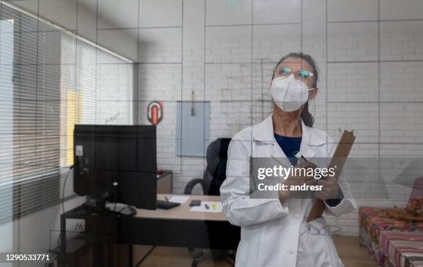 thoughtful business owner wearing a facemask while working at a textile factory - biosecurity stock pictures, royalty-free photos & images