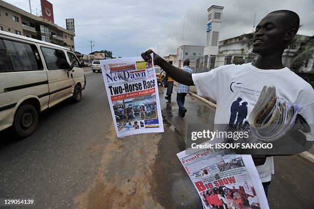 Man sells newspapers on a street in Monrovia on October 12 a day after Liberia's second post-war polls in which incumbent president Ellen Johnson...