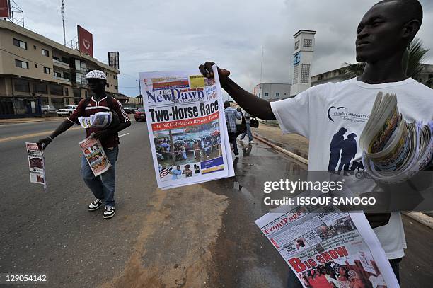 People sell newspapers on a street in Monrovia on October 12 a day after Liberia's second post-war polls in which incumbent president Ellen Johnson...