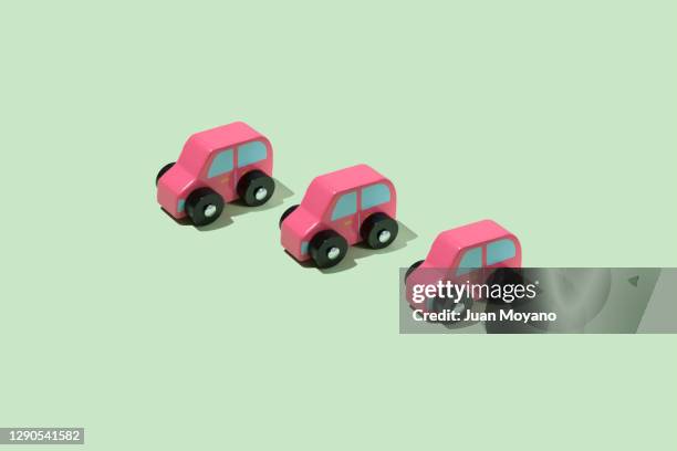 three toy cars on a green background - legno rosa foto e immagini stock