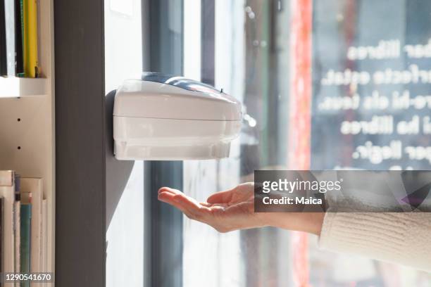 donna che utilizza lavatrice distributore automatico di gel disinfettante per le mani - dispenser foto e immagini stock