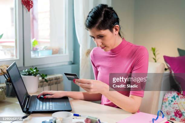 woman shopping online with laptop, smart phone and credit card - assistive technology student stock pictures, royalty-free photos & images