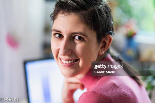 beautiful young woman with cochlear implant - hearing loss at work stock pictures, royalty-free photos & images