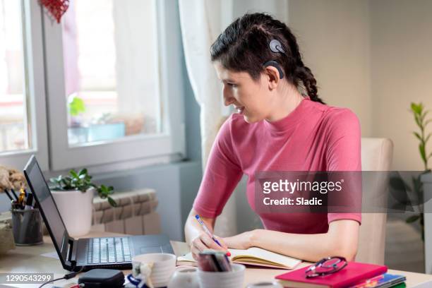 beautiful young woman with cochlear implant - hearing loss at work stock pictures, royalty-free photos & images