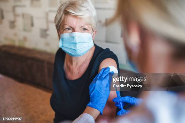 patient getting vaccination at home - aged care vaccine stock pictures, royalty-free photos & images