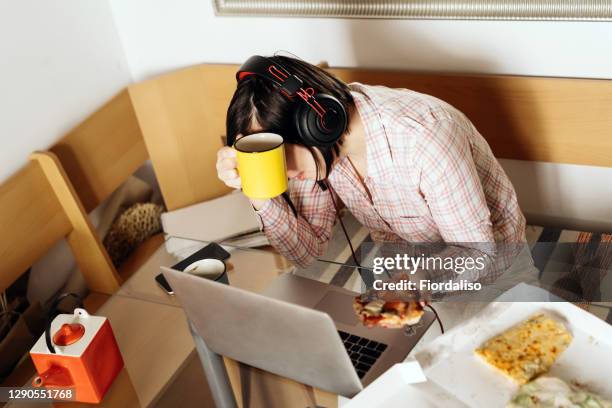 a middle-aged woman sitting in the kitchen at the glass table - covid 19 food stock pictures, royalty-free photos & images