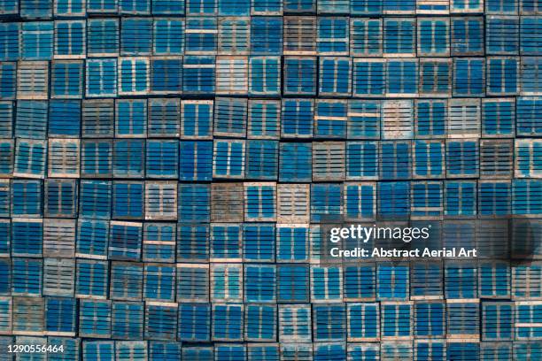 drone shot looking down on a stack of blue coloured pallets, england, united kingdom - pallet stockfoto's en -beelden