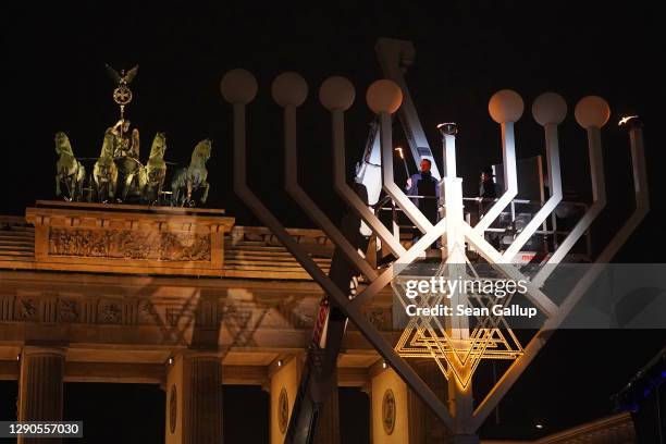 German Health Minister Jens Spahn and Rabbi Yehuda Teichtal stand on an elevated platform to symbolically light the first light on a giant menorah in...