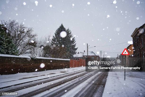 snow falling on a city street - belgium street stock pictures, royalty-free photos & images