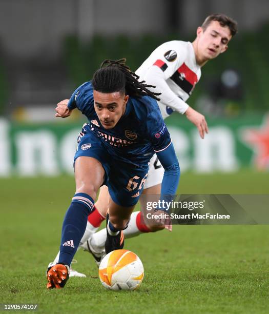 Miguel Azeez of Arsenal breaks past James Wynne of Dundak during the UEFA Europa League Group B stage match between Dundalk FC and Arsenal FC at...