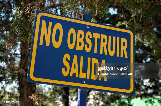 spanish-language warning sign stating 'no obstruir salida' [do not block exit] - obstruir stock pictures, royalty-free photos & images
