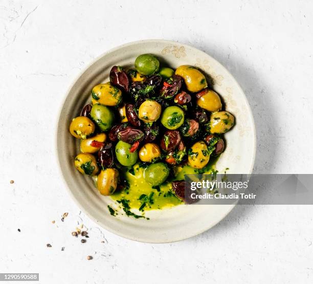 bowl of marinated olives on white background - marinated stock pictures, royalty-free photos & images