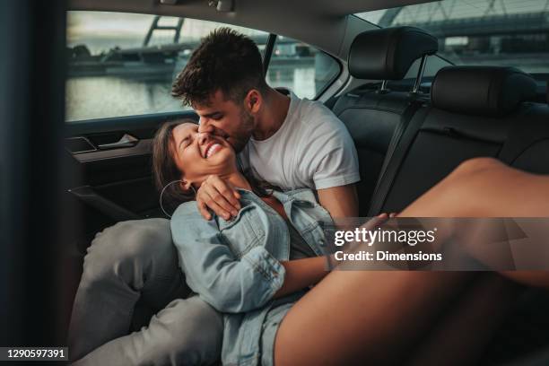 couple having a good time in the backseat - kissing car stock pictures, royalty-free photos & images