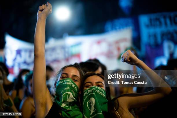 Pro-choice activist pose for a photo while raising their fists outside the National Congress as Deputies vote on a bill to legalize abortion on...