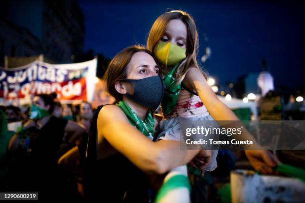 Pro-choice activist holds a little girl while waiting outside the National Congress as Deputies vote on a bill to legalize abortion on December 10,...