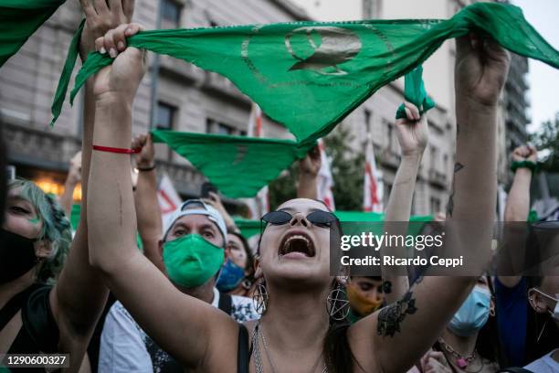 Pro-choice demonstrator holds up a green kerchief and shouts slogans outside the National Congress as Deputies vote on a bill to legalize abortion on...