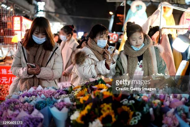 Residents bargain for vendor at a night market on December 10, 2020 in Wuhan, Hubei Province, China. Wuhan, with no recorded cases of Covid-19...