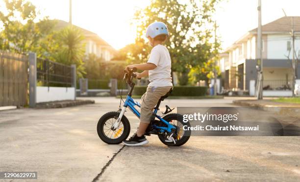 little boy riding bicycle - roue vélo photos et images de collection