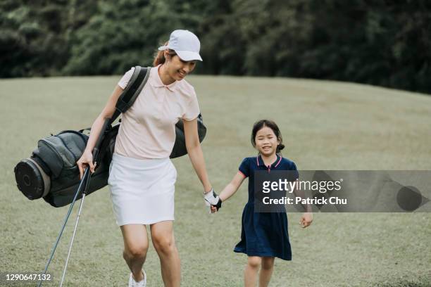 asian mature woman single mother with her daughter having bonding time at golf course - kids clubhouse stock pictures, royalty-free photos & images