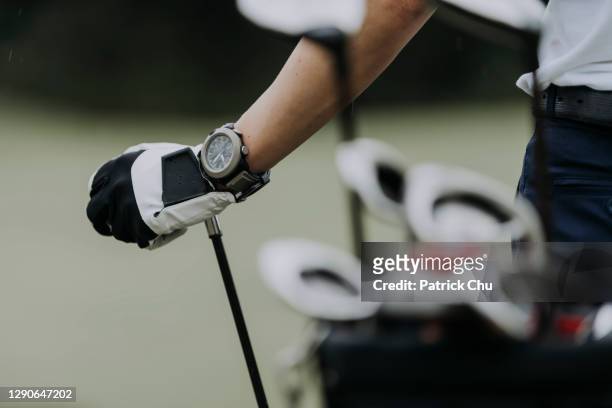 nahaufnahme der hand des golfers mit golfschläger auf dem golfplatz - golfhandschuh stock-fotos und bilder