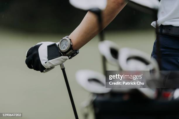 sluit omhoog van de hand van de golfer met golfclub bij golfcursus - golf clubhouse stockfoto's en -beelden