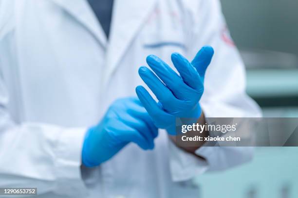 primer plano del médico masculino que lleva guantes - guante quirúrgico fotografías e imágenes de stock
