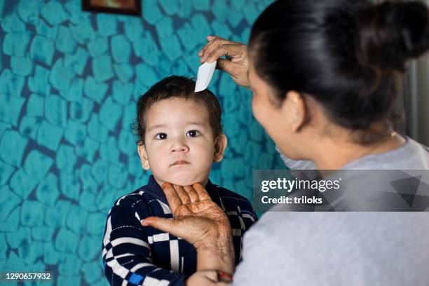 woman combing hair of son at home - combing stock pictures, royalty-free photos & images