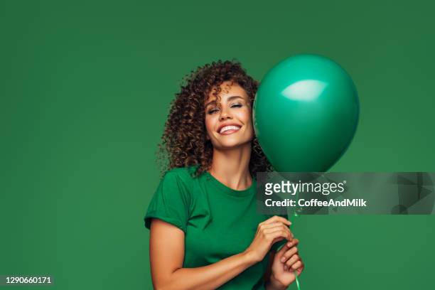beautiful woman holding a green balloon - balloon woman party stock pictures, royalty-free photos & images