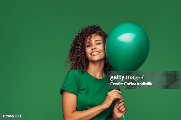 vacker kvinna som håller en grön ballong - party balloons bildbanksfoton och bilder