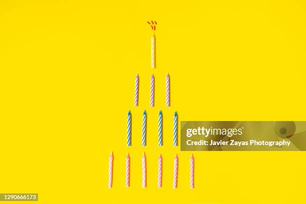 birthday cake formed by tart candles on yellow background - birthday candle fotografías e imágenes de stock