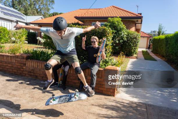 people doing skateboard tricks on the sidewalk - encouragement stock pictures, royalty-free photos & images