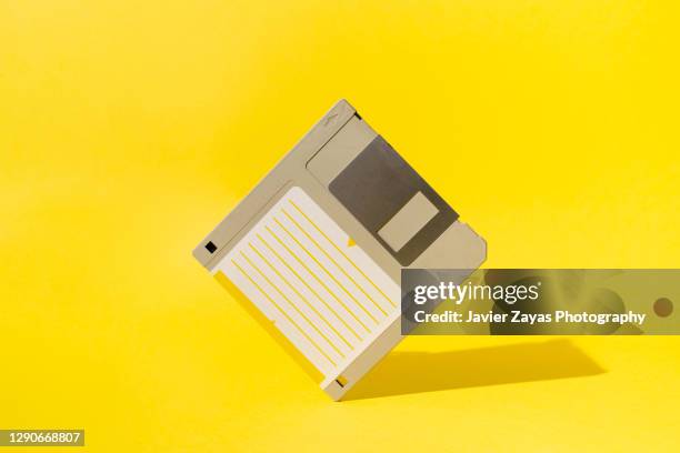 floppy disk on yellow background - obsolete software stock pictures, royalty-free photos & images