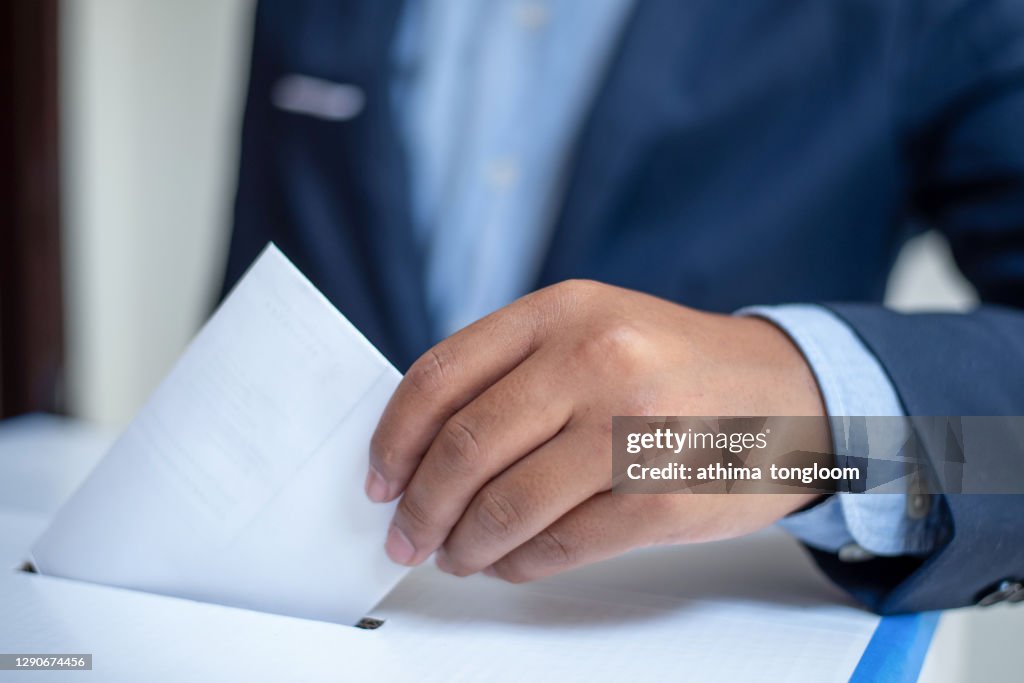 Ballot box with person casting vote.