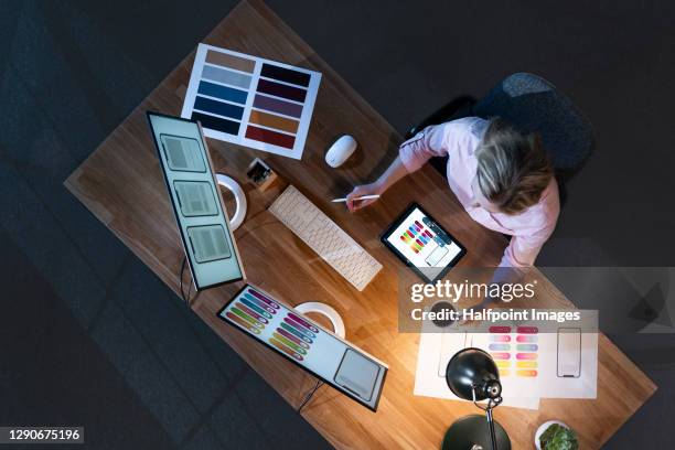 top view of businesswoman working at desk at night, using computer. - graphic designer stock pictures, royalty-free photos & images